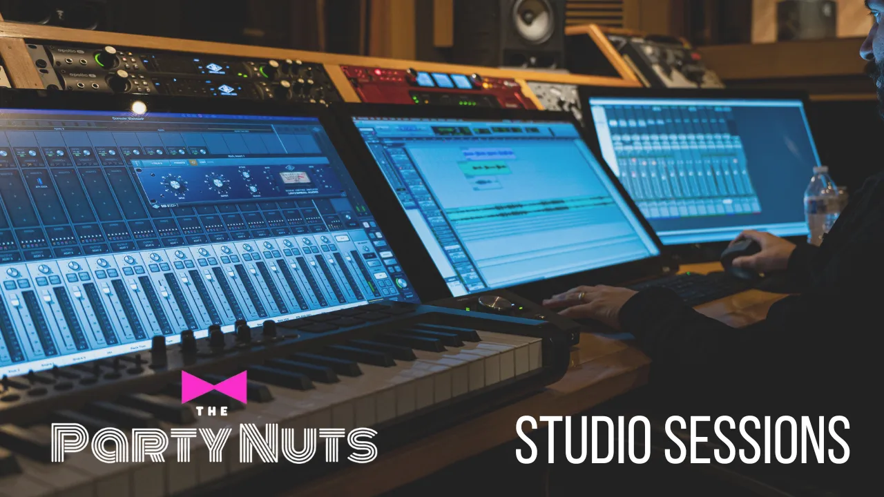 Music production studio with mixing console, keyboards, and three monitors displaying audio editing software, with a person working on a computer mouse.